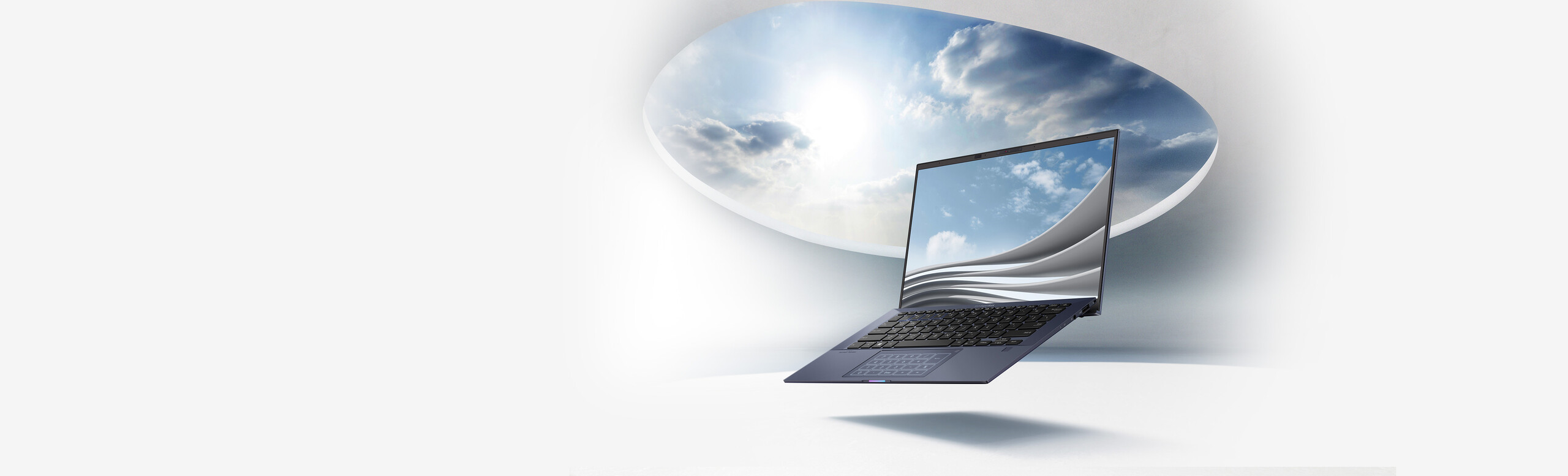 An ASUS ExpertBook B9 is in the middle with sunlight   spreading from the blue sky.