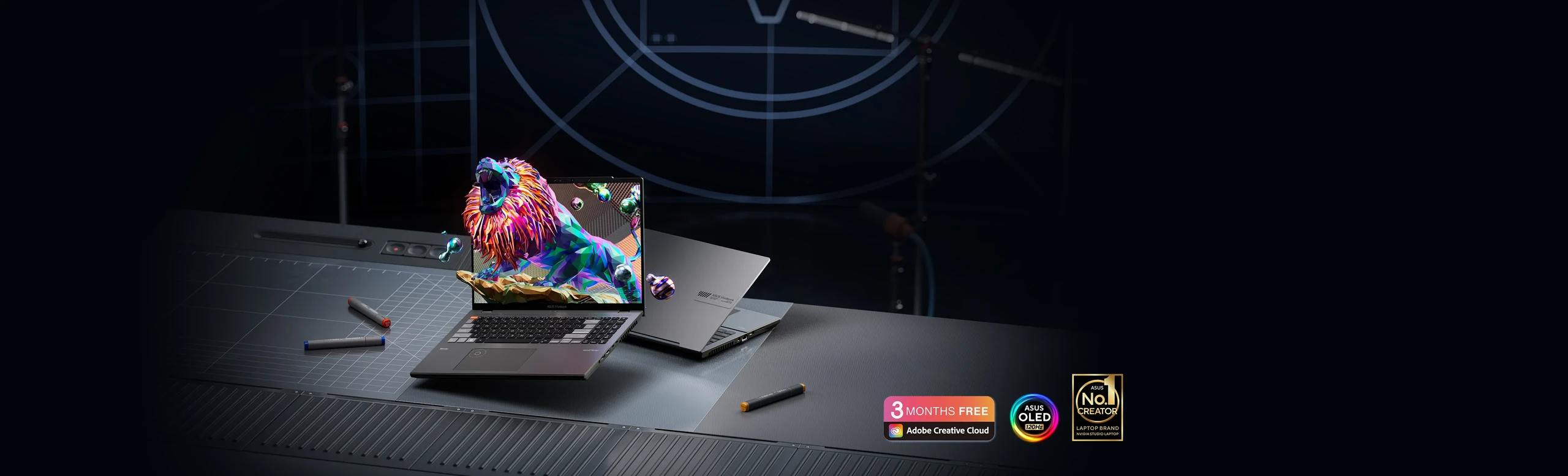 A silver and black model of the Vivobook Pro 16X 3D OLED are shown with the black model showing the in-screen of a lion roaring. The No1 Creator, ASUS Badge and Adobe 3 month logo are placed under the two models.