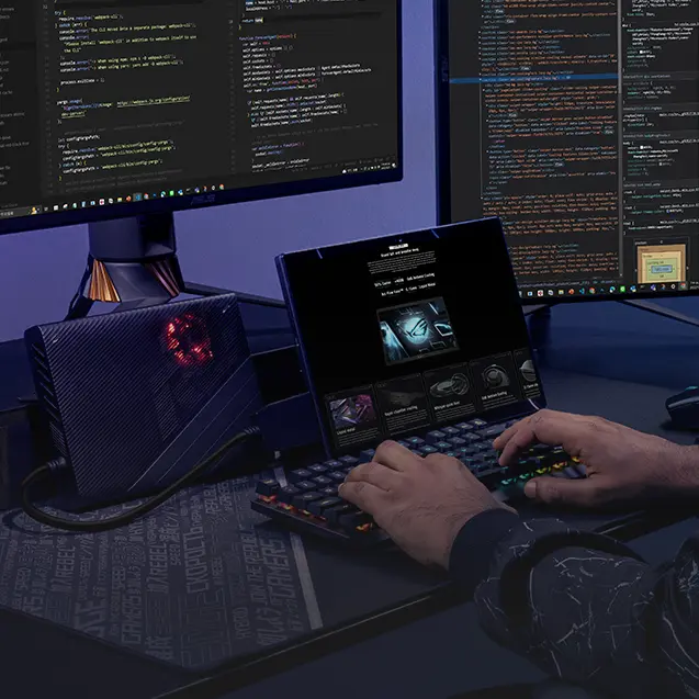 A man with dual external monitors, keyboard, speakers, XG Mobile, mouse, and Flow Z13 on a desk.