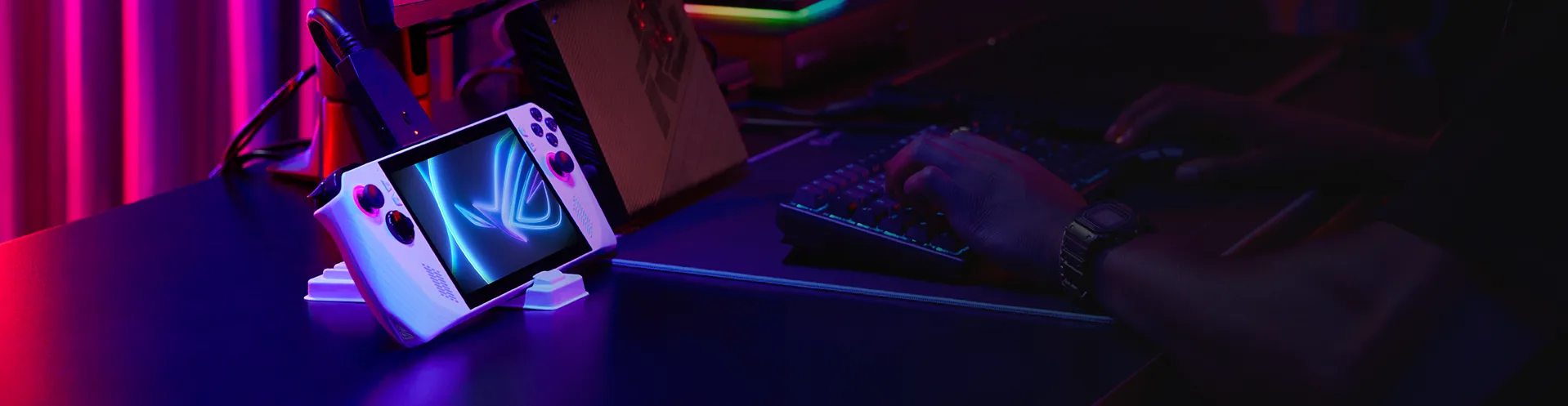 A young man is playing video game with ROG Ally connected to his desktop monitor.